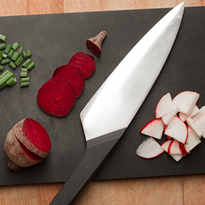 A sleek chef's knife on a cutting board.